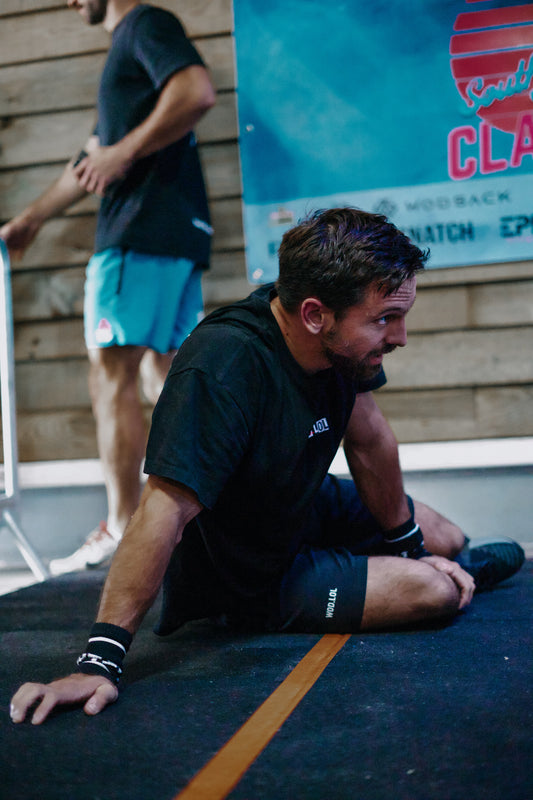 Athlète assis au sol en t-shirt WOD.LOL, récupération après l'effort